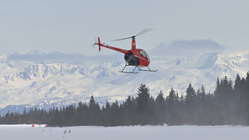 HOMER, AK CIRCA 2012: Red 2-man helicopter (Robinson R22) flying away toward