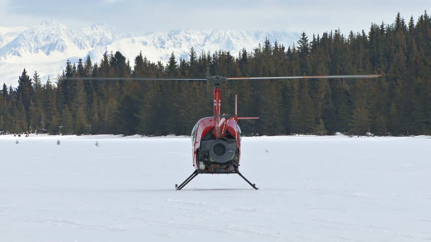 HOMER, AK CIRCA 2012: Red 2-man helicopter (Robinson R22) lifting off from rest