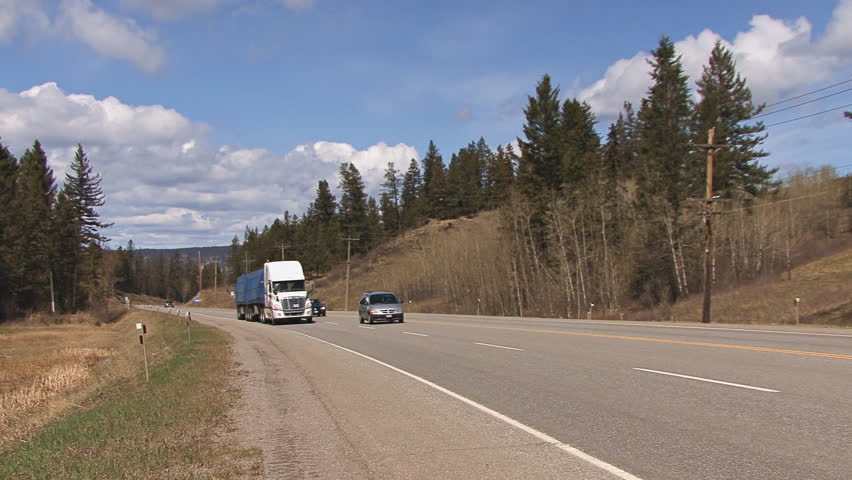 BRITISH COLUMBIA, CANADA - CIRCA 2012: Two tractor-trailer trucks pass by on the