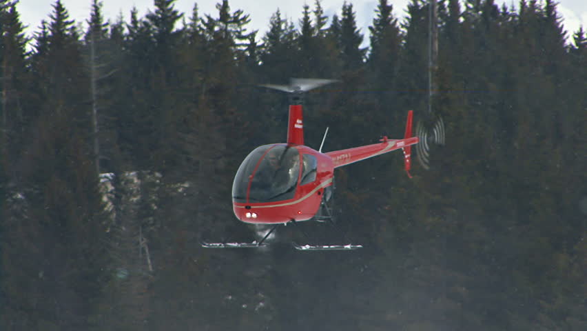 HOMER, AK CIRCA 2012: Red 2-man helicopter (Robinson R22) hovering low over a