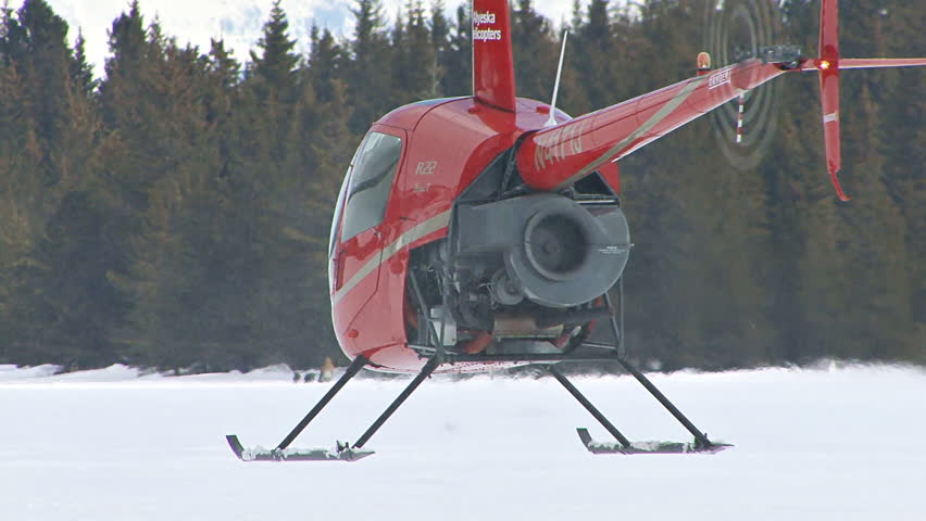 HOMER, AK CIRCA 2012: Red 2-man helicopter (Robinson R22) hovers over frozen