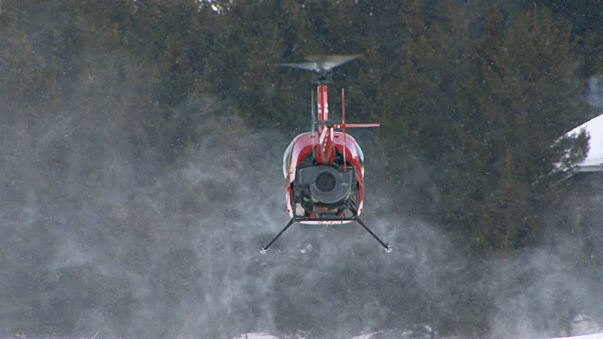 HOMER, AK CIRCA 2012: Red 2-man helicopter (Robinson R22) hovering low over a