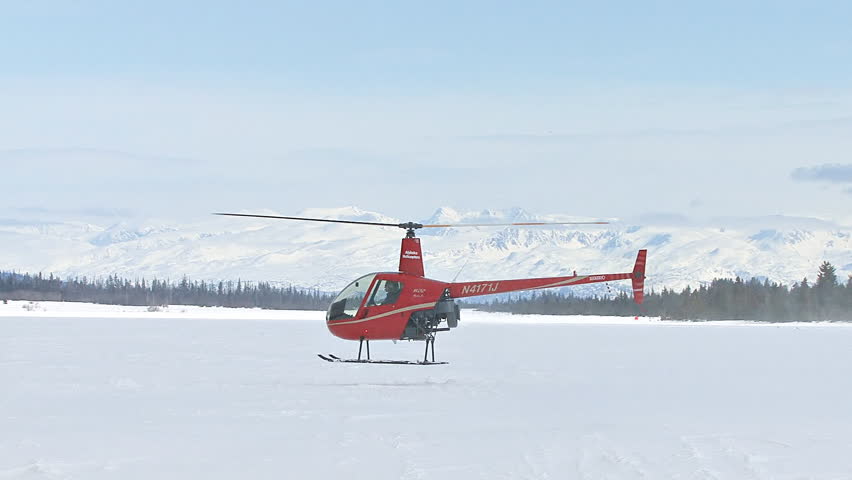 HOMER, AK CIRCA 2012: Red 2-man helicopter (Robinson R22) flying low, turns and