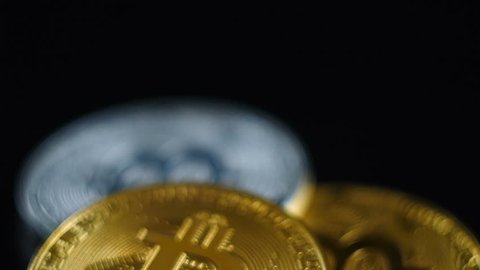 Gold and silver bitcoins lie on a black background.