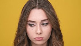 Close up view of upset brunette woman looking around over orange background
