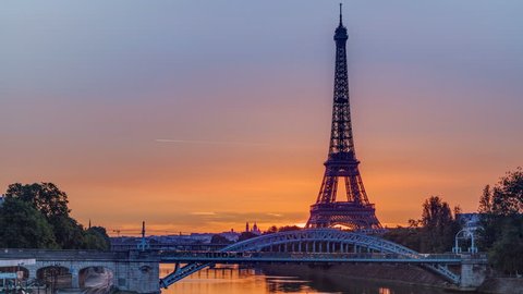 Eiffel Tower sunrise timelapse with boats on Seine river and in Paris, France. View from Grenelle bridge.