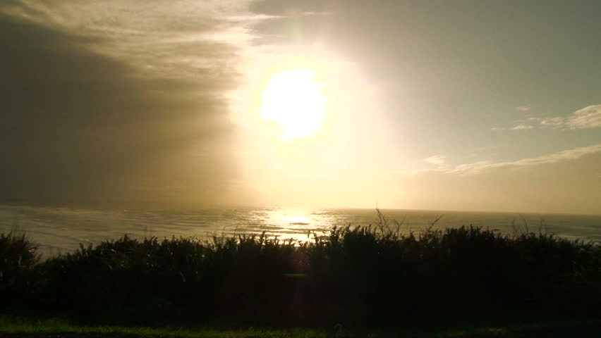 Bright sun shines over the Pacific Ocean on beautiful day, zoom out.