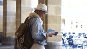 Senior woman traveling in european city, reading map