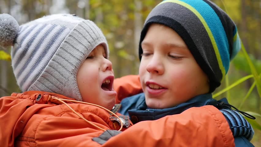 Boy hugging crying younger brother and holding him in my arms