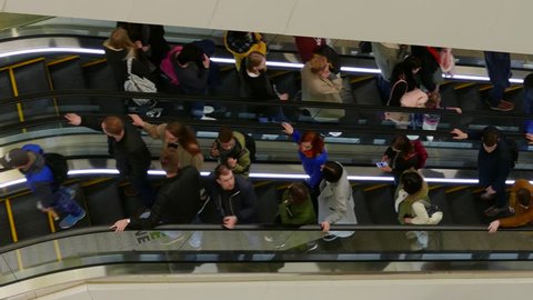 MINSK, BELARUS - APR 9, 2017: Ungraded: People on escalators. Buyers are moving on escalators inside a multi-storey shopping center. Ungraded H.264 from camera without re-encoding. (av38053u)