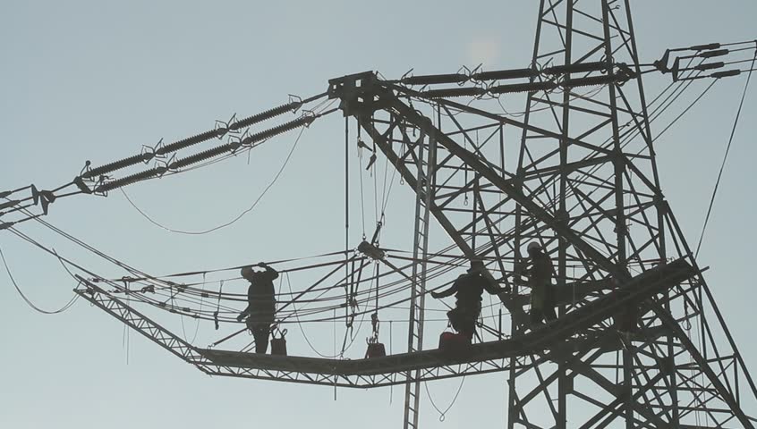 Men working on transmission line silhouettes