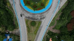 Roundabout from top view or bird view and zoom in/out video. Have a car passing.