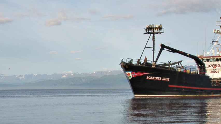 HOMER, AK - CIRCA 2012: Large crabbing vessel moves through scenic bay waters on