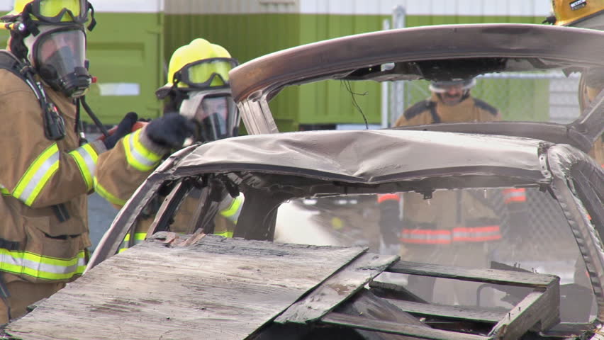 HOMER, AK - CIRCA 2012: Volunteer Firefighters dousing a burnt smoking car with