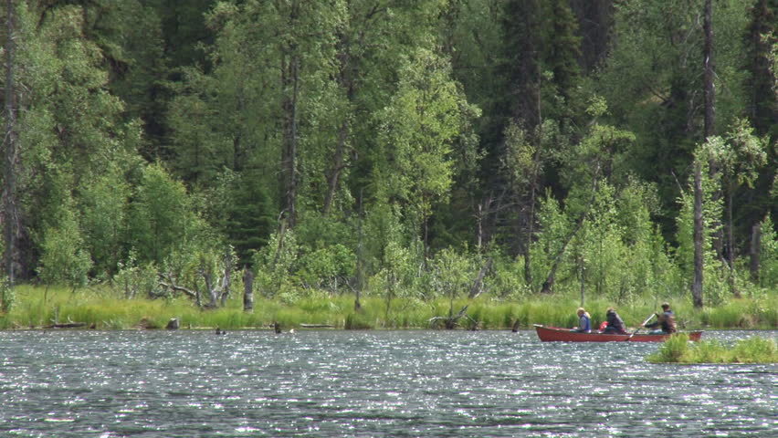 WHITTIER, AK - CIRCA 2012: Three people in a red canoe on Tern Lake in Alaska.