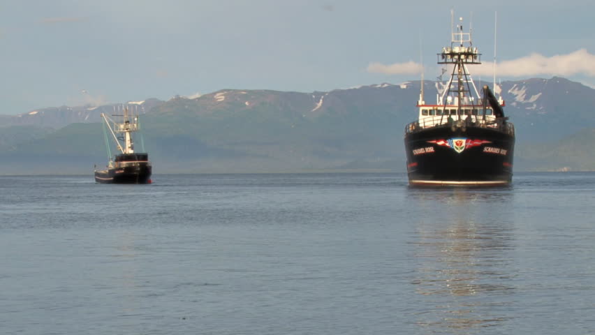 HOMER, AK - CIRCA 2012: A large crab boat and a fishing trawler move closer