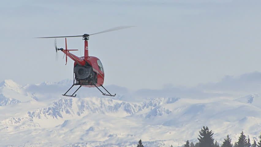HOMER, AK - CIRCA 2012: Red 2-man helicopter (Robinson R22) hovering low over