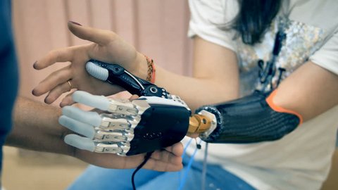Young woman trying wireless bionic prosthesis. 4K.