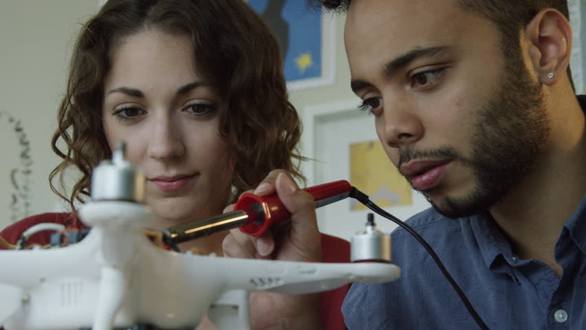 Drone repair in slow motion. Man and Woman Technology Team