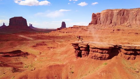 CIRCA 2010s - Monument Valley, Utah - Excellent aerial over a cowboy on horseback overlooking Monument Valley, Utah.