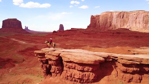 CIRCA 2010s - Monument Valley, Utah - Remarkable aerial over a cowboy on horseback overlooking Monument Valley, Utah.