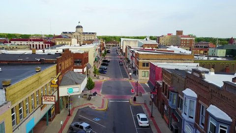 CIRCA 2010s - United States - A lovely aerial over a Main Stret in small town USA ends with two kids skateboarding down the empty boulevard.