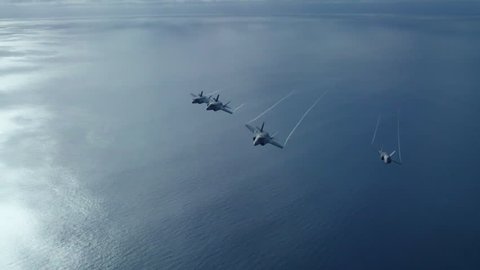 CIRCA 2010s - US Navy fighter jets fly over an aircraft carrier.
