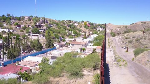 CIRCA 2010s - U.S.-Mexico border - Forward aerial along the U.S Mexican border wall fence reveals the town of Nogales.