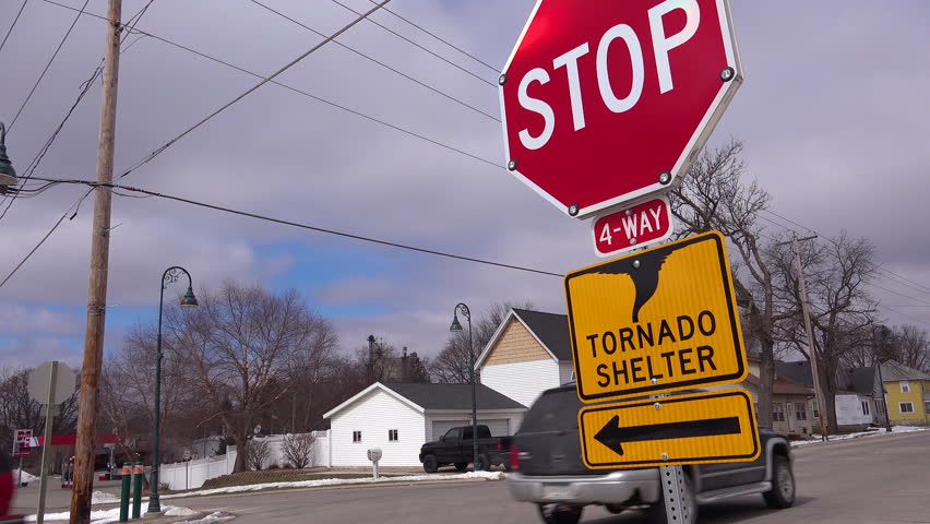 CIRCA 2010s - United States - Signs indicate the direction to a tornado shelter as a storm approaches.