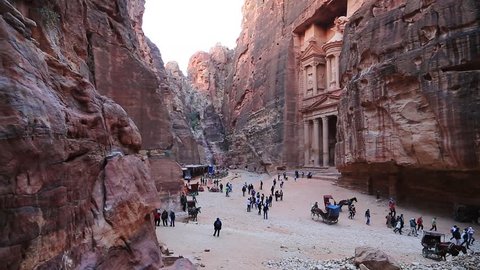People and animals near Al Khazneh or the Treasury at ancient Petra, originally known to Nabataeans as Raqmu - historical and archaeological city in Hashemite Kingdom of Jordan