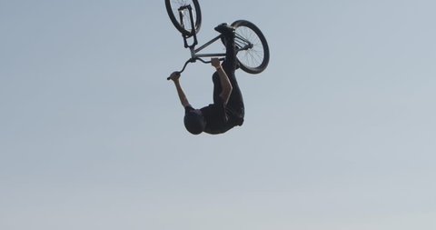 BMX athlete doing tricks on a jump in slow motion