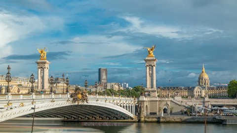 Bridge of Alexandre III spanning the river Seine timelapse. Decorated with ornate Art Nouveau lamps and sculptures. View from embankment. Paris. France. Blue cloudy sky before sunset