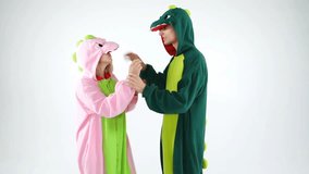 dinosaur costumes absurd dancing couple. Funny party mood. White background video footage