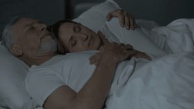 Old couple sleeping in bed, lady lying on male chest, man holding arm around her - Powered by Shutterstock - Get 15% off with code: PIKWIZARD15