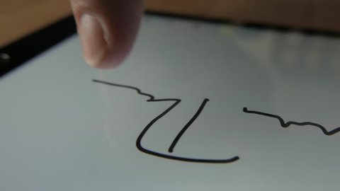 Man signing his name on a tablet screen. E-signature or digital signature.