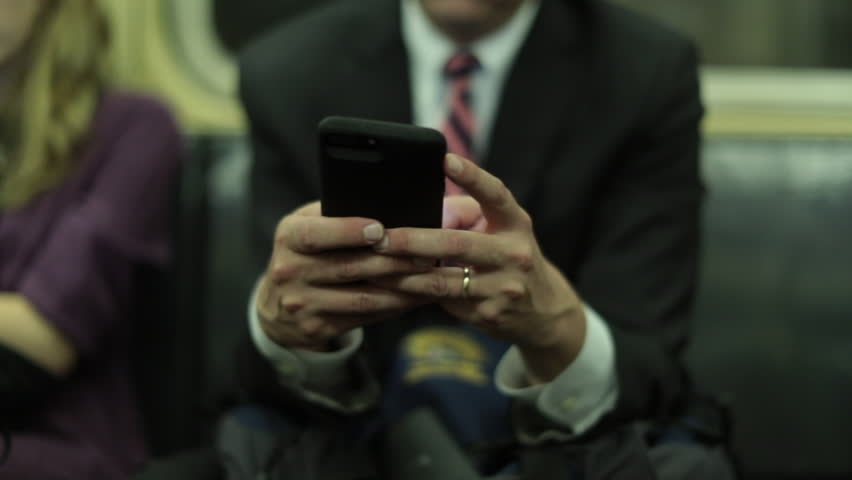 Close-up of hands typing on cellphone. Person on mobile phone while on metro