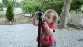 Kid playing with a monopod, child is exploring the monopod