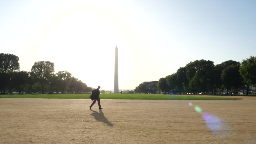 Man walking against Washington Monument on a Bright Sunny Day
