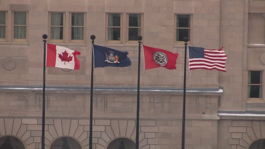 Four flags flying in a cold winter wind in Niagara Falls, NY. The flags are