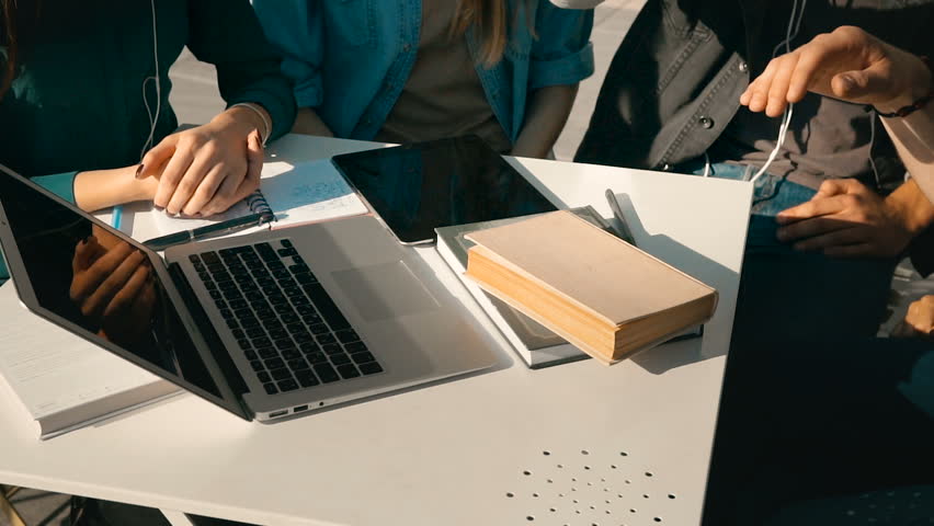 Teamwork cooperation emotions of group of students, hands stick together, table with laptop and books before modern building, sunny day 120FPS slowmotion Royalty-Free Stock Footage #31422073