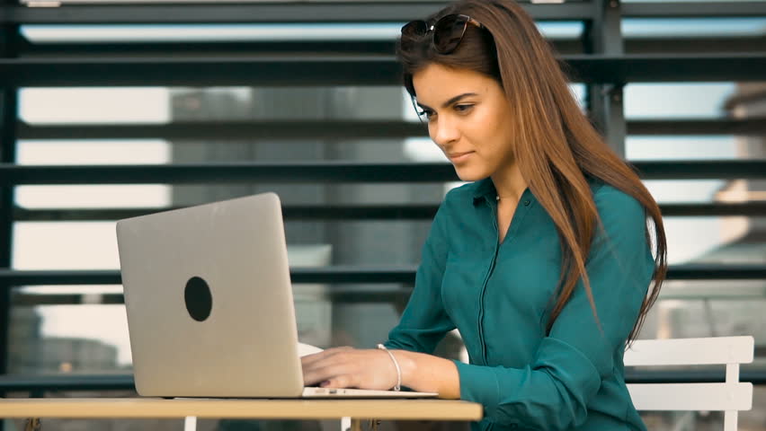 Beautiful student girl works with laptop computer outdoors before moder building wall, slowmotion Royalty-Free Stock Footage #31422712