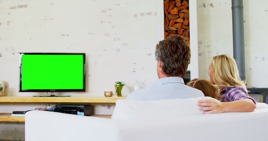 Rear view of Caucasian family watching television in living room at home 4k
