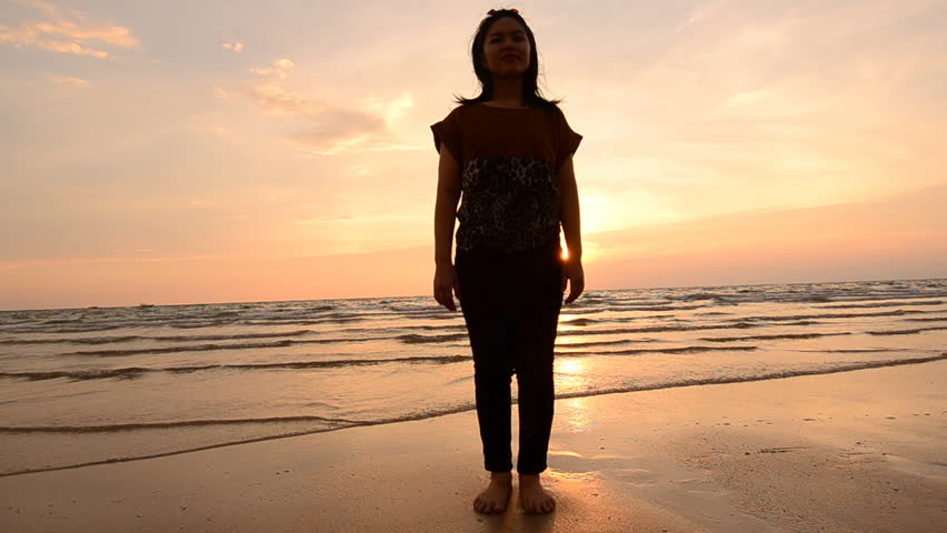 silhouette Asian woman practicing yoga at the beach and Sunset view.(HD)