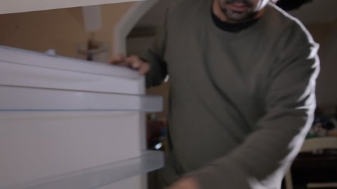 A man picking and leaving items from a fridge. POV inside the refrigerator.

