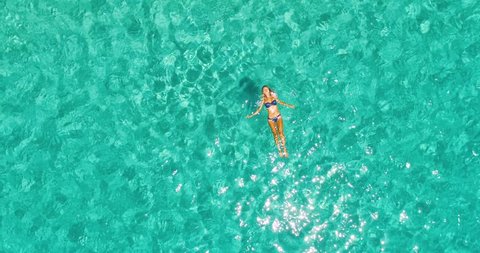 Aerial view of woman floating in amazing clear waters