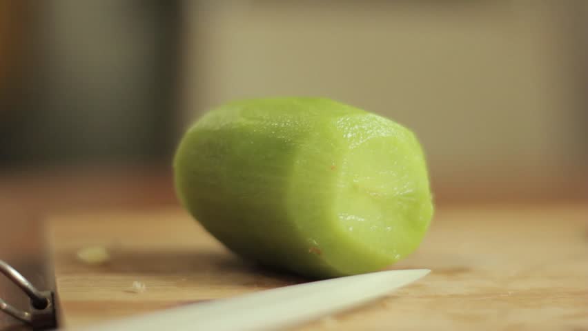 Slicing a kiwi. Close-up man hand with knife