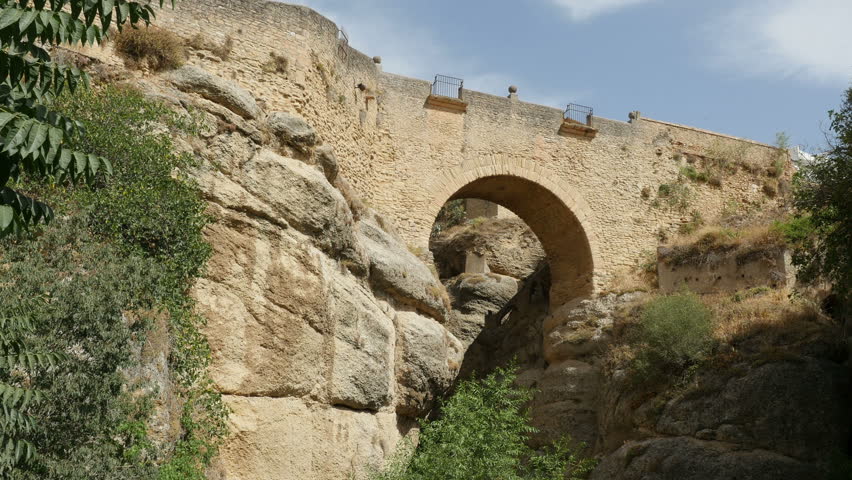 Low angle view of the Puente Romano bridge (the Roman Bridge) in Ronda city, Spain, 4k footage