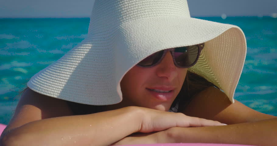 
a seaside girl in full relax is relaxing by taking the sun in a caribbean sea and quiet. concept of beach vacation and relaxation, sun creams and happiness.