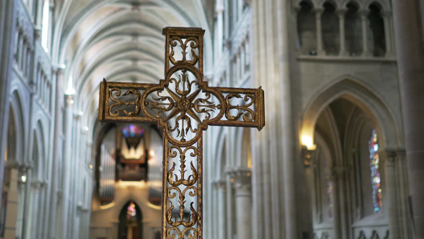 Holy crucifix in a bright cathedral / Beautiful golden cross in a cinematic ancient church