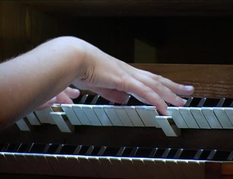 hands play on organ